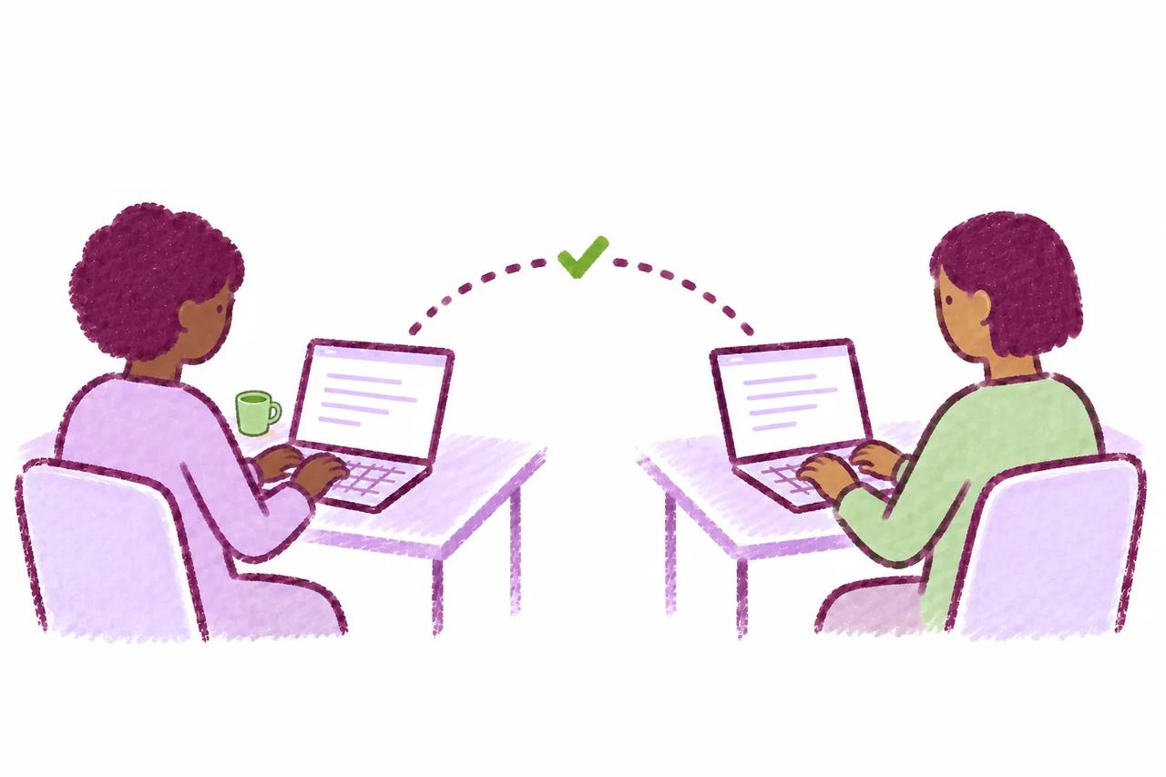 Two writers with different skin tones collaborating from separate laptops